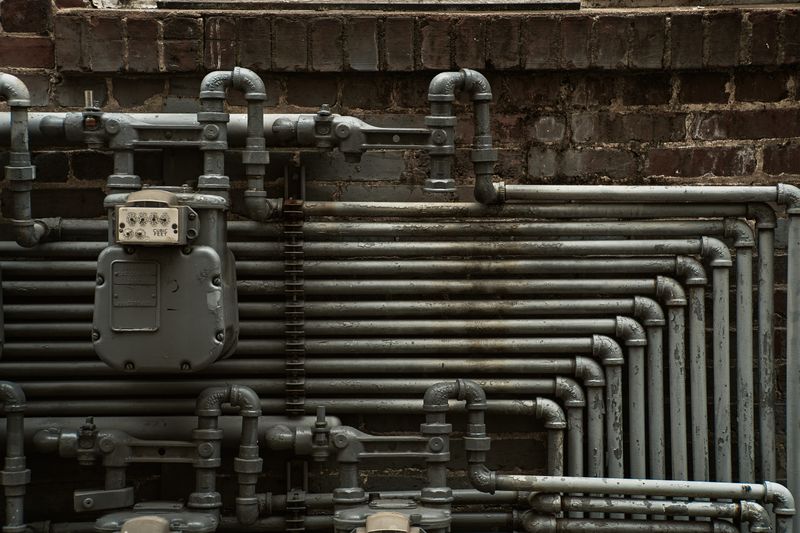 Tuberías de plomería expuestas en pared de construcción