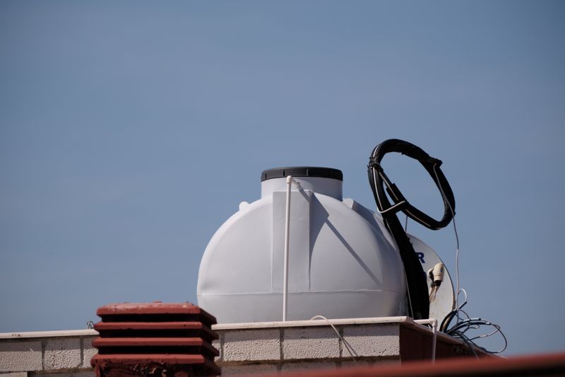 Tanque de agua en azotea con tuberías de plomería